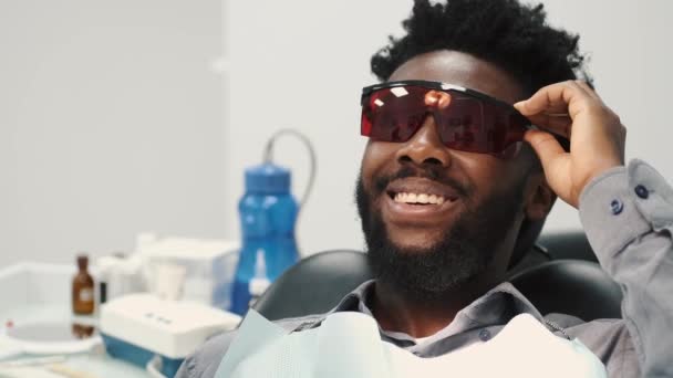 Boční záběr mladého muže bělícího zuby na zubaře — Stock video