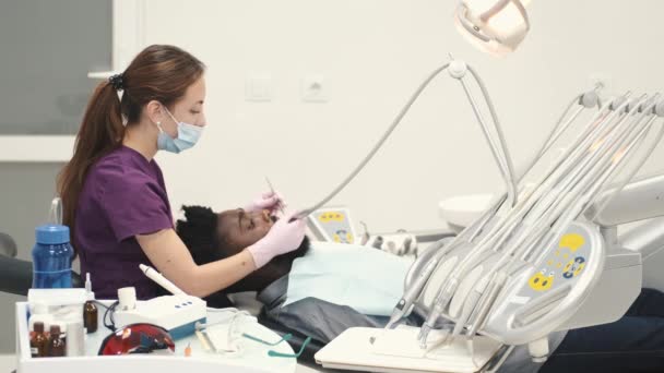 Professionell tandläkare som arbetar med handskar under tentamen — Stockvideo