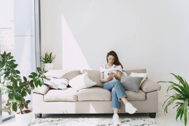 Evdeki rahat kanepede dinlenen kadın.