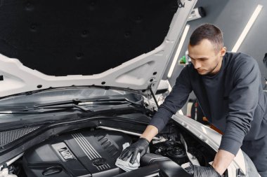 İstasyonda motoru yıkayan adam.