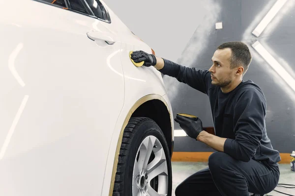Man polish a car in a garage — Stock Photo, Image