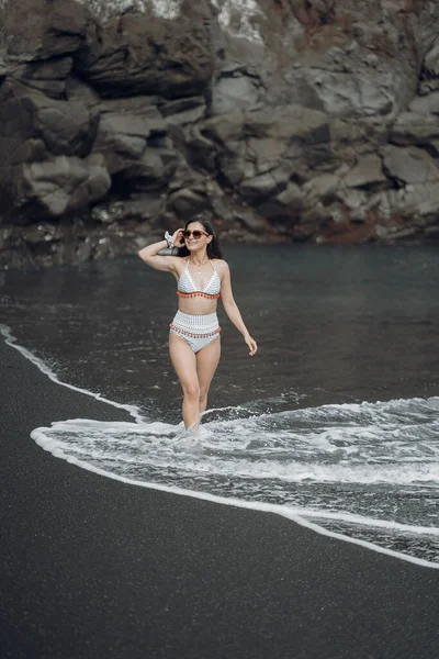 La ragazza in un costume da bagno elegante ha un riposo n una spiaggia — Foto Stock