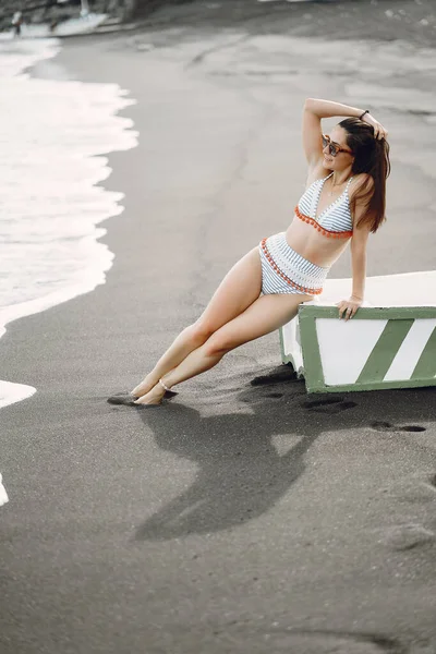 Girl in a stylish swimsuit have a rest on a beach — Stock Photo, Image