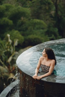 Orman manzaralı havuzda bir kadın.