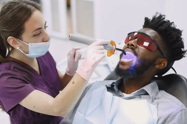 Doente africano em odontologia sentado em cadeira dentária — Fotografia de Stock