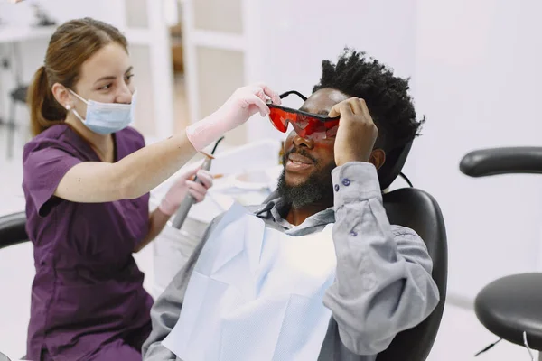 Paciente africano en odontología sentado en silla dental — Foto de Stock