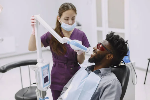 Paciente africano en odontología sentado en silla dental — Foto de Stock