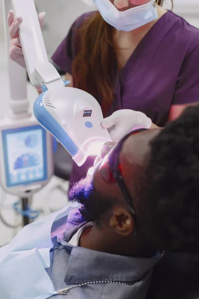 Paciente africano en odontología sentado en silla dental — Foto de Stock