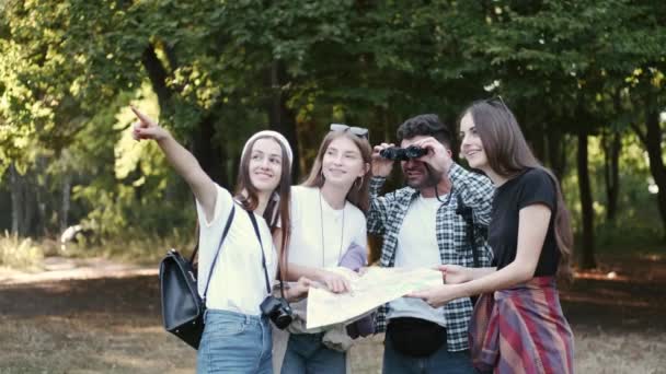 Skupina turistů, kteří hledají místa na mapě venku — Stock video