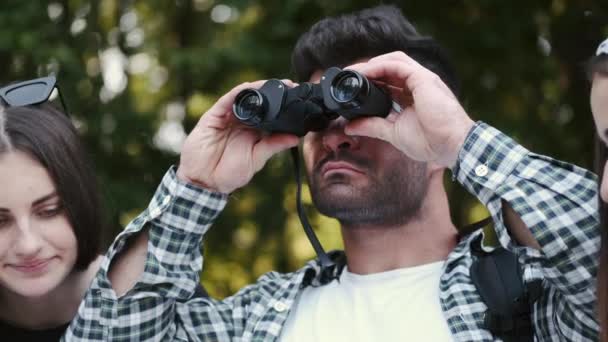 Pemuda tampan sedang menonton di teropong di hutan — Stok Video