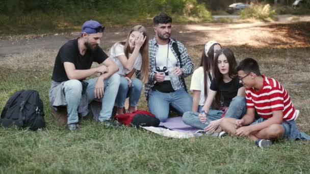 Círculo de amigos sentados na floresta e conversando — Vídeo de Stock