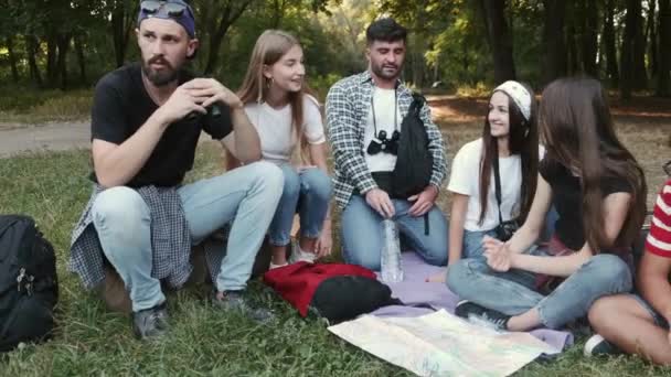 Círculo de amigos sentados na floresta e conversando — Vídeo de Stock