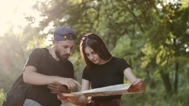 Genç gezginler ormanda durup haritada yer arıyorlar.