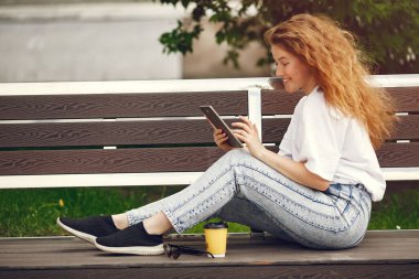 Bir şehirde elinde tabletle oturan öğrenciler