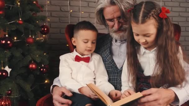 Grand-père et enfants lisant un livre la veille de Noël — Video