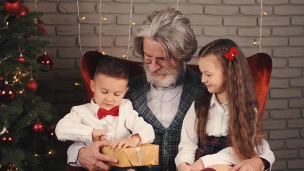 祖父とクリスマスの贈り物を持つ子供たち — ストック動画