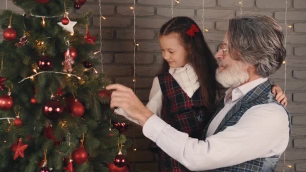 Moderní stylový děda a dítě zdobí vánoční stromeček — Stock video
