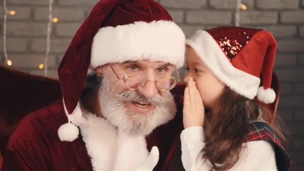 Fille en chapeau rouge chuchotant un souhait de Père Noël — Video