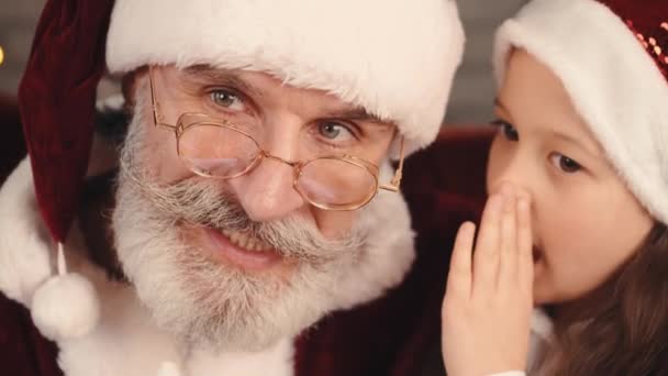 Fille en chapeau rouge chuchotant un souhait de Père Noël — Video