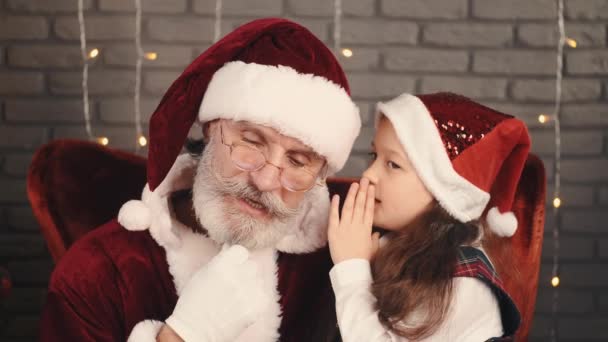 Ragazza in cappello rosso sussurrando un desiderio di Babbo Natale — Video Stock