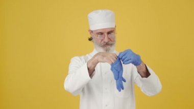 Tıbbi şapkalı adam fotokopi alanında tek kullanımlık eldiven takmış.