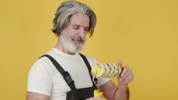 Worker holding paint brush and smiling on yellow background — Stock Video