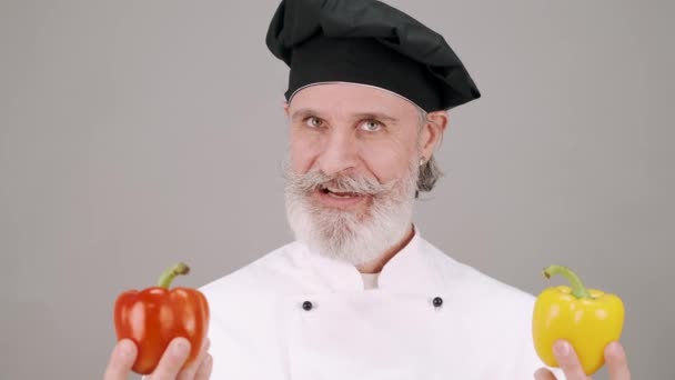 Chef profesional divertido con pimientos aislados — Vídeo de stock