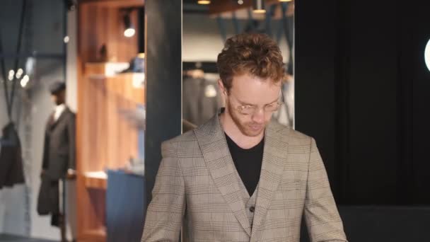 Hombre escogiendo ropa en la tienda de ropa para hombre — Vídeos de Stock