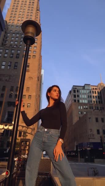 Joven mujer sonriente de pie en el puente. Fondo de la ciudad. — Vídeos de Stock