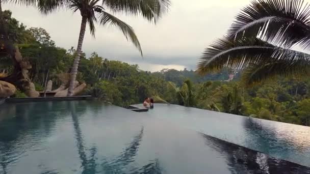 在巴厘岛乌巴迪的游泳池里接吻的情侣 — 图库视频影像