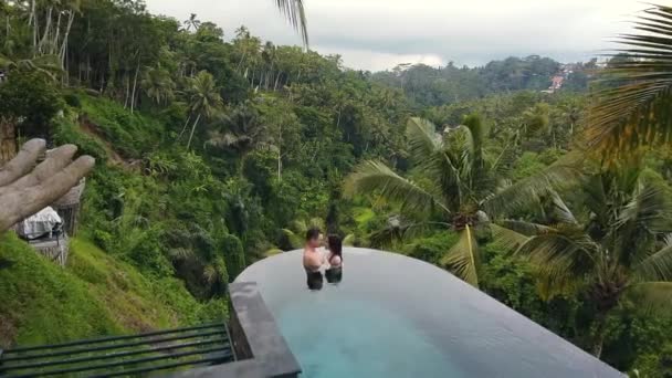 Пара целуется в бассейне прямо в джунглях на Бали Индонезия — стоковое видео
