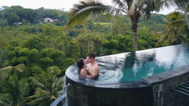 Ζευγάρι φιλιά στην πισίνα ακριβώς στη ζούγκλα στο Μπαλί — Αρχείο Βίντεο