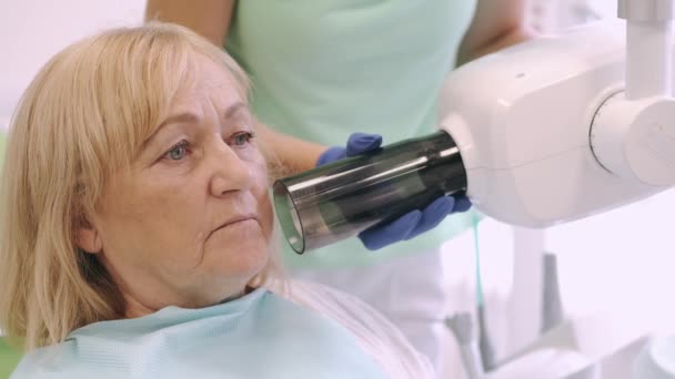 Sandalyedeki hastaya diş röntgeni çeken kadın dişçi ya da teknisyen. — Stok video