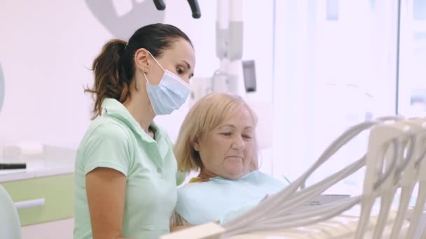 Dentista e paciente olhando para raio-x juntos — Vídeo de Stock