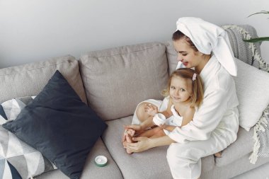 Anne ve kızı bornoz ve havlu giymiş.