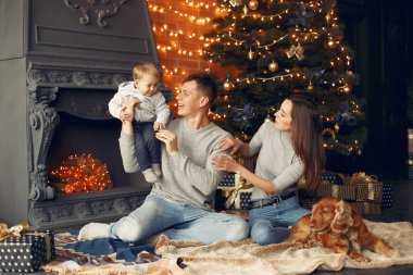 Noel ağacının yanında sevimli köpekli bir aile.