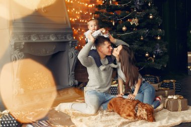 Noel ağacının yanında sevimli köpekli bir aile.