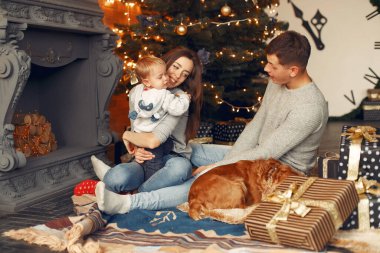 Noel ağacının yanında sevimli köpekli bir aile.