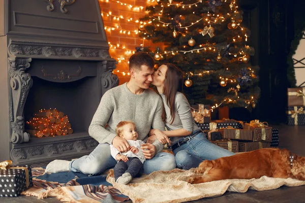 Familia con lindo perro en casa cerca del árbol de Navidad — Foto de Stock