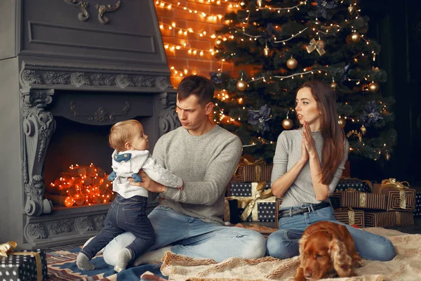 Rodina s roztomilým psem doma v blízkosti vánoční strom — Stock fotografie