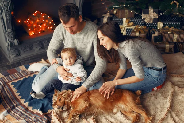 Familia con lindo perro en casa cerca del árbol de Navidad — Foto de Stock