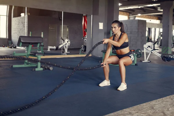 Deportiva morena en un entrenamiento de ropa deportiva en un gimnasio — Foto de Stock