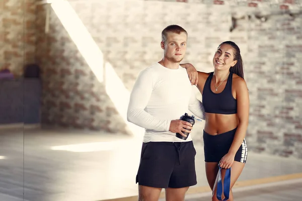 Pareja deportiva en un entrenamiento de ropa deportiva en un gimnasio —  Fotos de Stock