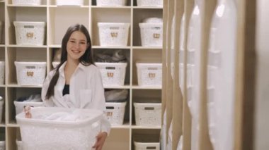 Woman with laundry basket in self-service laundry