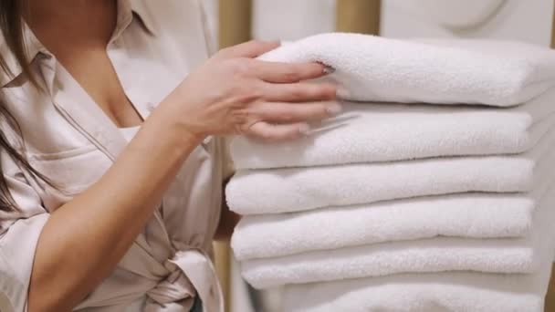 Młoda dama sortowanie czyste ręczniki w pralni — Wideo stockowe