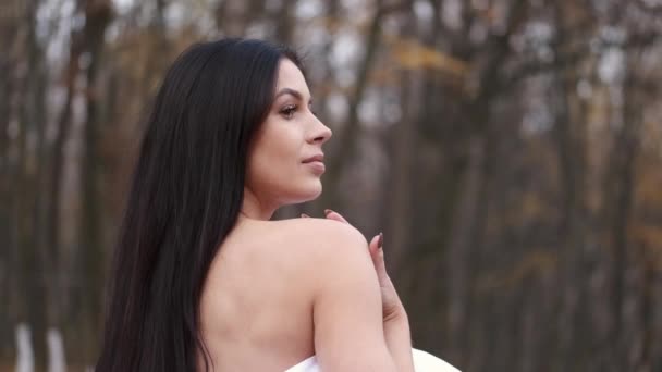 Tânără femeie frumoasă înfășurată în pătură plimbare în natură în toamnă — Videoclip de stoc