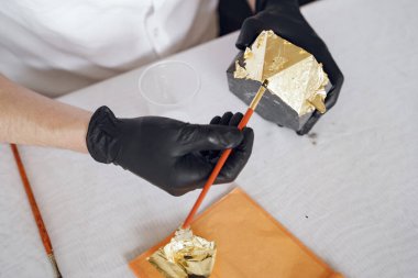 Beyaz gömlekli adam çimentoyla çalışıyor.