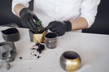 Beyaz gömlekli adam çimentoyla çalışıyor.