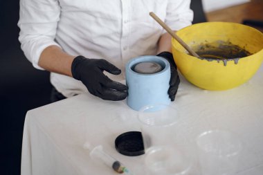 Beyaz gömlekli adam çimentoyla çalışıyor.