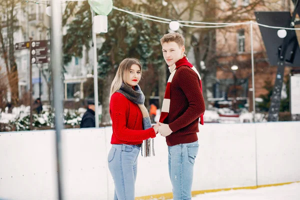 Casal bonito em uma camisola vermelha se divertindo em uma arena de gelo — Fotografia de Stock